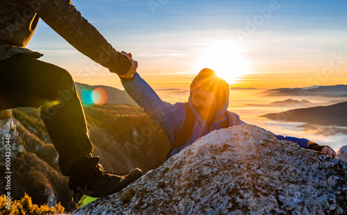 Hiking team people helping each other friend giving a helping hand while climbing up on the mountain rock adventure travel concept of support trust teamwork success. photo