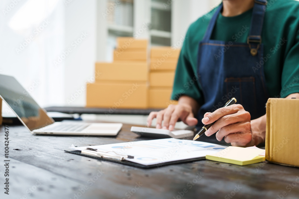 A man is working at his desk, preparing parcel boxes for shipment. He checks and packs items carefully, using shockproof materials, and attaches labels before sending them to customers via EMS. A man is working at his desk, preparing parcel boxes for shipment. He checks and packs items carefully, using shockproof materials, and attaches labels before sending them to customers via EMS.