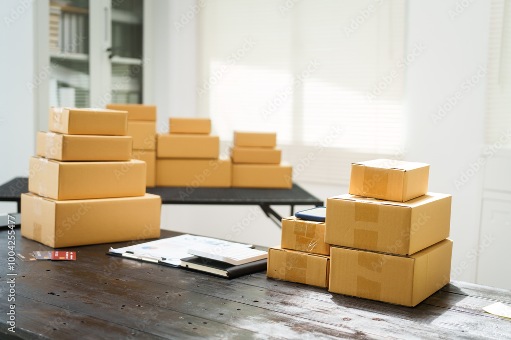 A desk is filled with boxes in warehouse,ready for shipment.Products are packed securely using shockproof materials.Labels tracking numbers are attached for online orders before shipping via EMS A desk is filled with boxes in warehouse,ready for shipment.Products are packed securely using shockproof materials.Labels tracking numbers are attached for online orders before shipping via EMS