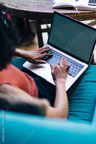 Back view of female programmer working remotely with initializing database via laptop application with blank screen for advertising text, skilled woman searching business website on netbook photo