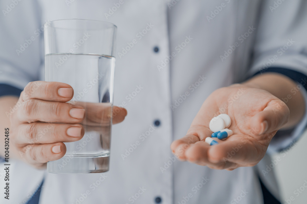 Cropped shot of doctor hands giving pills and glass of water Cropped shot of doctor hands giving pills and glass of water