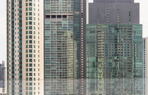 Architectural exterior of modern office building facade with blue sky and clouds reflection in windows. Steel frame and glass windows architecture, Space for text, Selective focus.