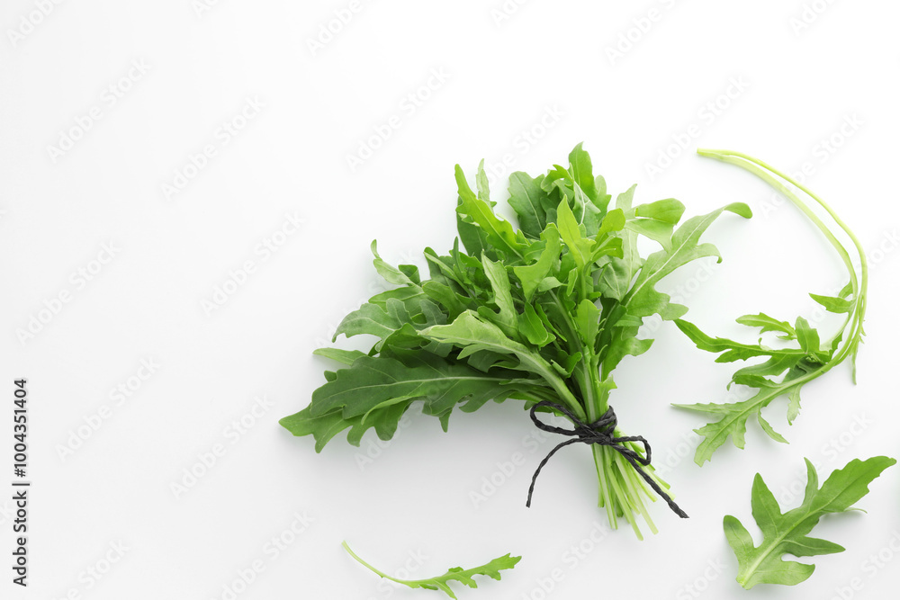 Fresh green arugula leaves on white background, flat lay. Space for text Fresh green arugula leaves on white background, flat lay. Space for text