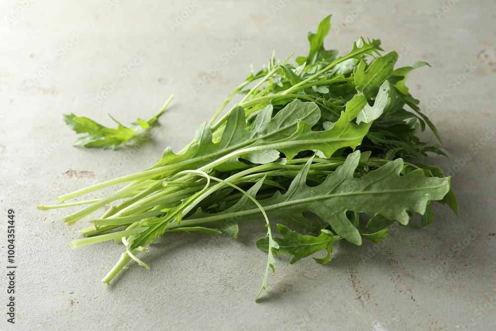 Many fresh arugula leaves on grey textured table Many fresh arugula leaves on grey textured table