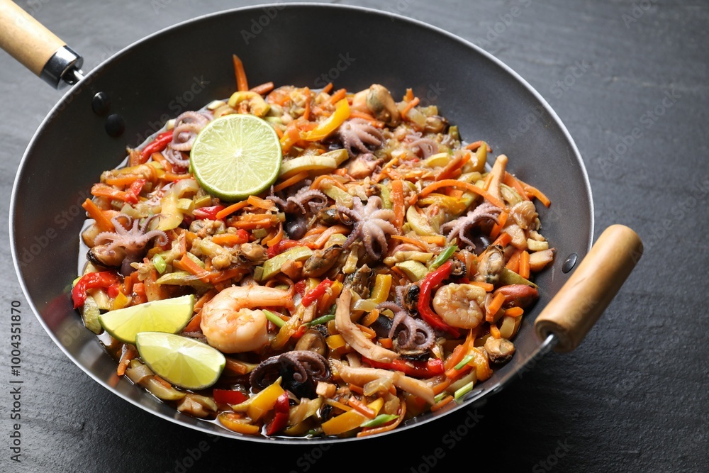 Stir-fry sea food in wok on grey textured table, closeup Stir-fry sea food in wok on grey textured table, closeup