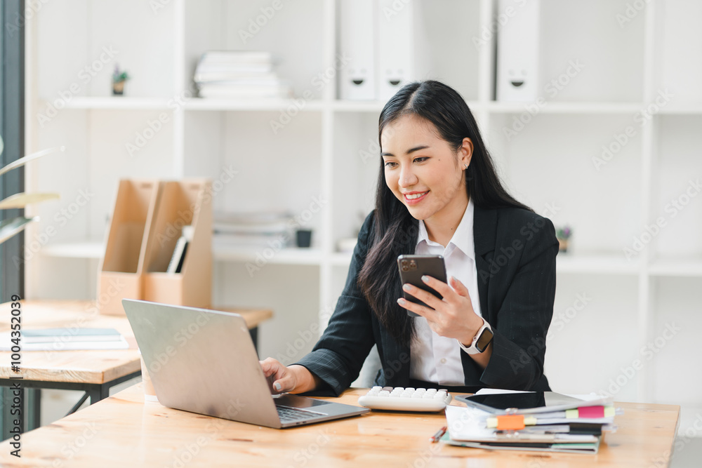 professional woman is engaged in multitasking at her modern office, using laptop and smartphone while surrounded by organized paperwork and stationery. Her focused expression reflects productivity professional woman is engaged in multitasking at her modern office, using laptop and smartphone while surrounded by organized paperwork and stationery. Her focused expression reflects productivity