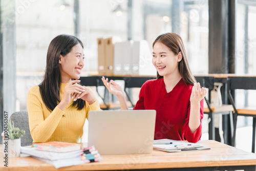 Two women engaged in lively conversation at modern workspace, sharing ideas and smiles. atmosphere is bright and collaborative, perfect for teamwork and creativity.