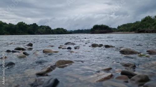 A river flows over rocks in this beautiful scene in the forest. River and clouds.
