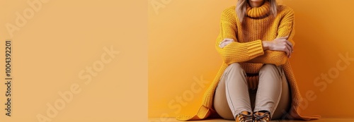 Woman in Yellow Sweater Sitting Against Yellow Wall