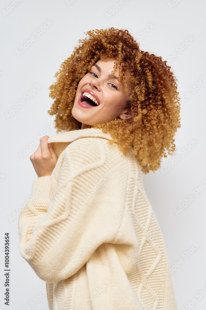 Smiling woman with curly hair in a cozy sweater against a plain light background, exuding warmth and happiness Natural beauty and lifestyle concept for fashion or portrait photography Smiling woman with curly hair in a cozy sweater against a plain light background, exuding warmth and happiness Natural beauty and lifestyle concept for fashion or portrait photography