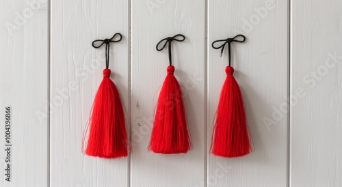 Bright Red Tassels Hanging on White Wooden Wall