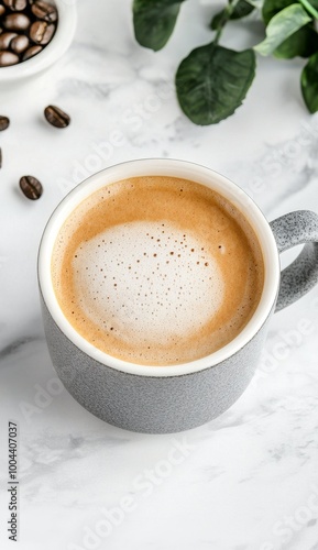 Creamy cappuccino in a white cup surrounded by coffee beans on a soft fabric ...