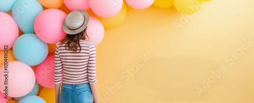 Girl in Straw Hat Enjoys Colorful Balloons at a Summer Celebration Outdoors