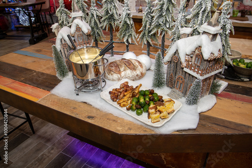 Obraz na płótnie A selection of Christmas food used for a festive fondue including sprouts and pigs in blankets surrounded by festive Christmas decorations on a wooden kitchen table w salonie