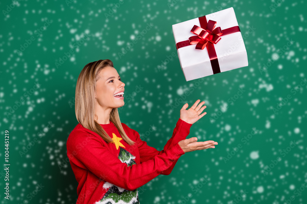 Portrait of attractive trendy cheerful girl throwing giftbox having fun isolated over green color background Portrait of attractive trendy cheerful girl throwing giftbox having fun isolated over green color background