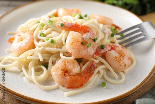 Delicious pasta with shrimps and green onions on table, closeup