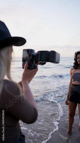  A beautiful model poses for a photographer on the ocean shore, capturing the essence of summer travel and adventure. This vibrant scene showcases the joy of photography and creating lasting memories.