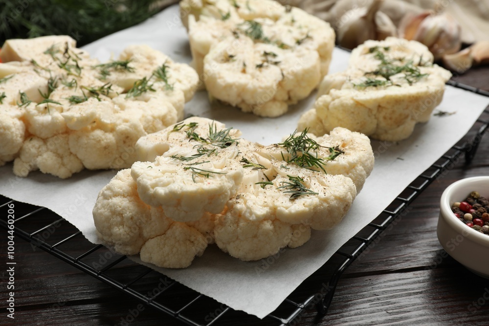 Uncooked cauliflower steaks with spices on wooden table, closeup Uncooked cauliflower steaks with spices on wooden table, closeup