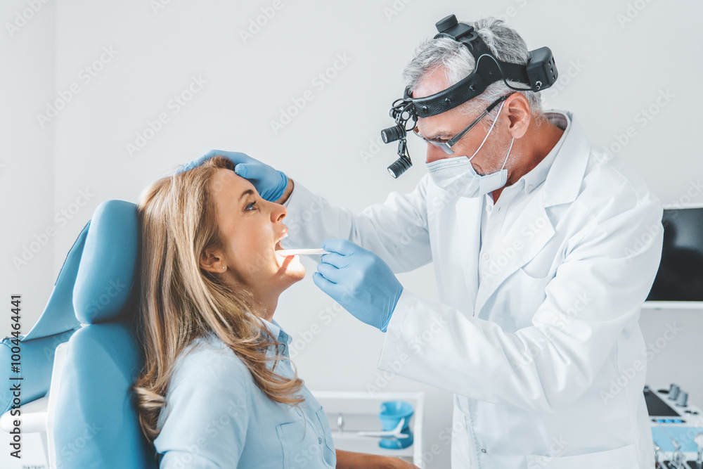 Experienced doctor examines adult woman for sore throat Experienced doctor examines adult woman for sore throat