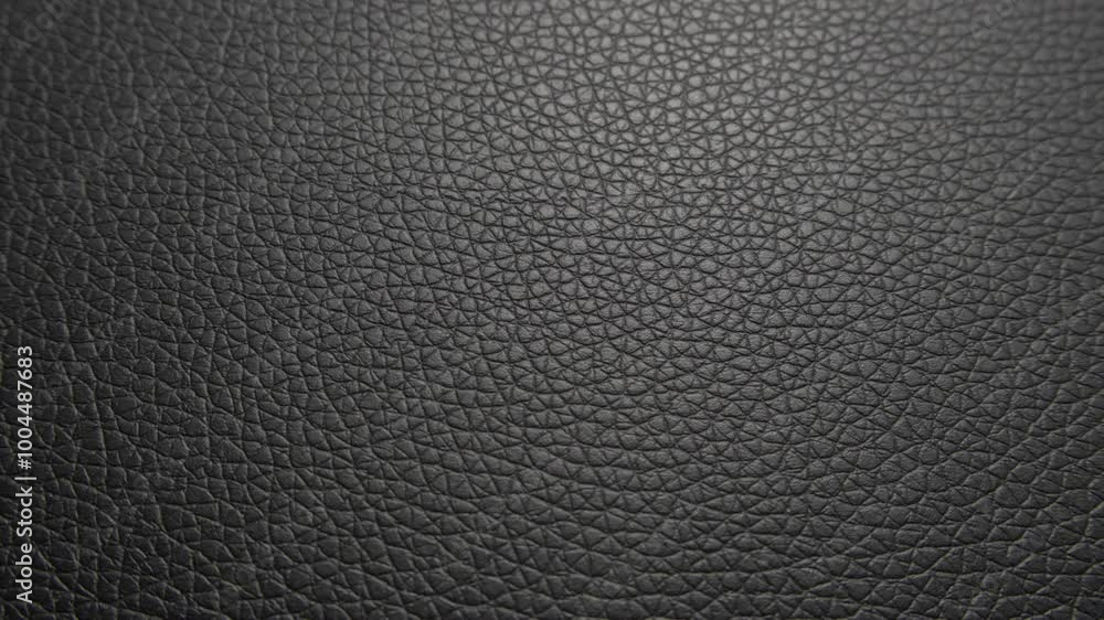 A detailed close-up of black leather, showcasing its natural grain and texture. The surface features fine creases and patterns that emphasize the materials premium quality and durability. A detailed close-up of black leather, showcasing its natural grain and texture. The surface features fine creases and patterns that emphasize the materials premium quality and durability.