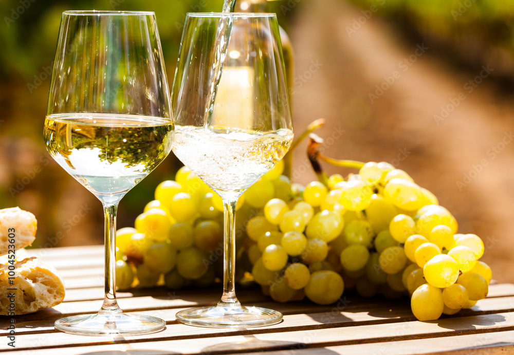 Glass of White wine ripe grapes and bread on table in vineyard Glass of White wine ripe grapes and bread on table in vineyard