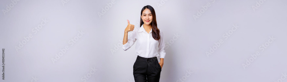 A portrait of a Southeast Asian businesswoman wearing a white dress shirt and giving a thumbs up. A portrait of a Southeast Asian businesswoman wearing a white dress shirt and giving a thumbs up.