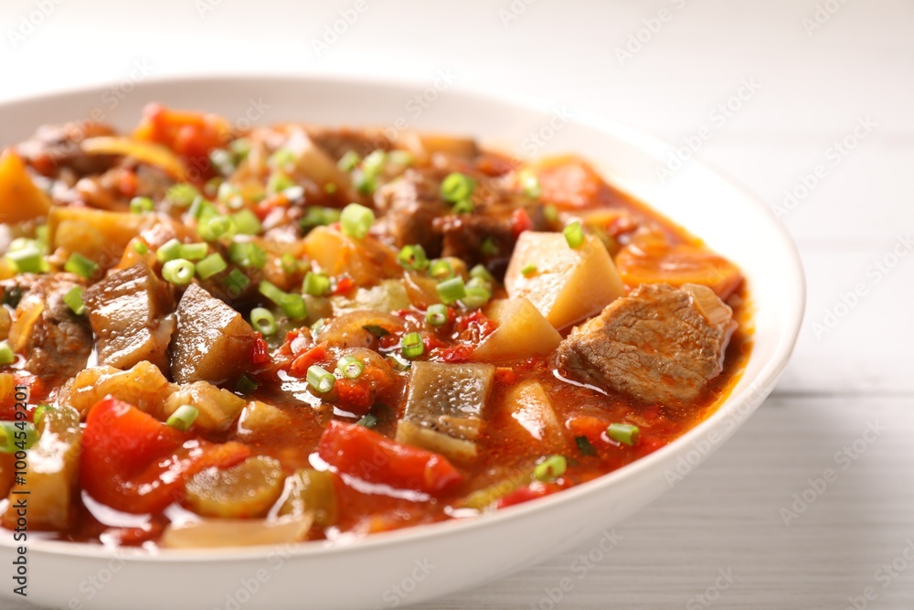Delicious stew with vegetables in bowl on white wooden table, closeup Delicious stew with vegetables in bowl on white wooden table, closeup