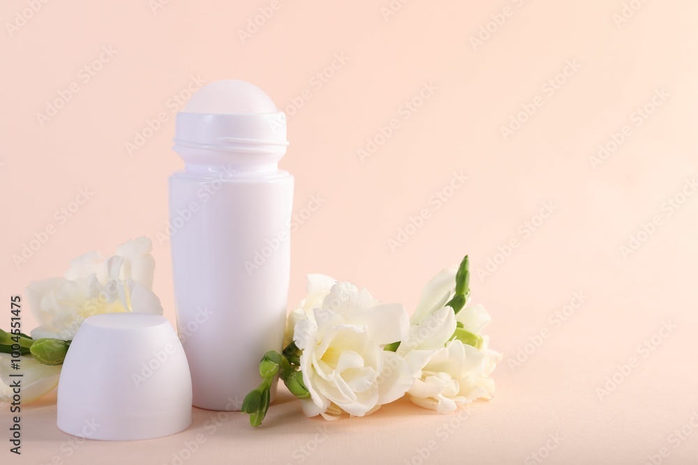 Roll-on deodorant and beautiful eustoma flowers on beige background Roll-on deodorant and beautiful eustoma flowers on beige background