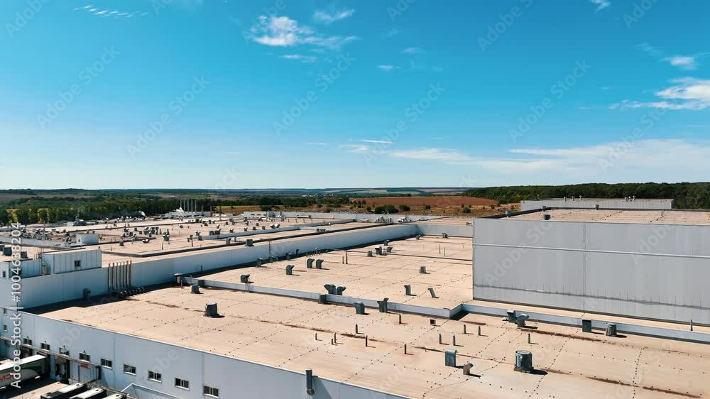 Roof of a huge industrial plant with multiple ventilation pumps on top. Aerial view on the modern factory located away from city. Roof of a huge industrial plant with multiple ventilation pumps on top. Aerial view on the modern factory located away from city.