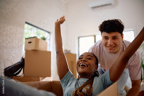 Cheerful multiracial couple having fun after relocating into new apartment. photo