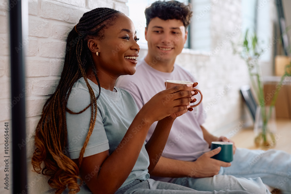Happy black woman enjoying in cup of coffee with her boyfriend in their new home. Happy black woman enjoying in cup of coffee with her boyfriend in their new home.