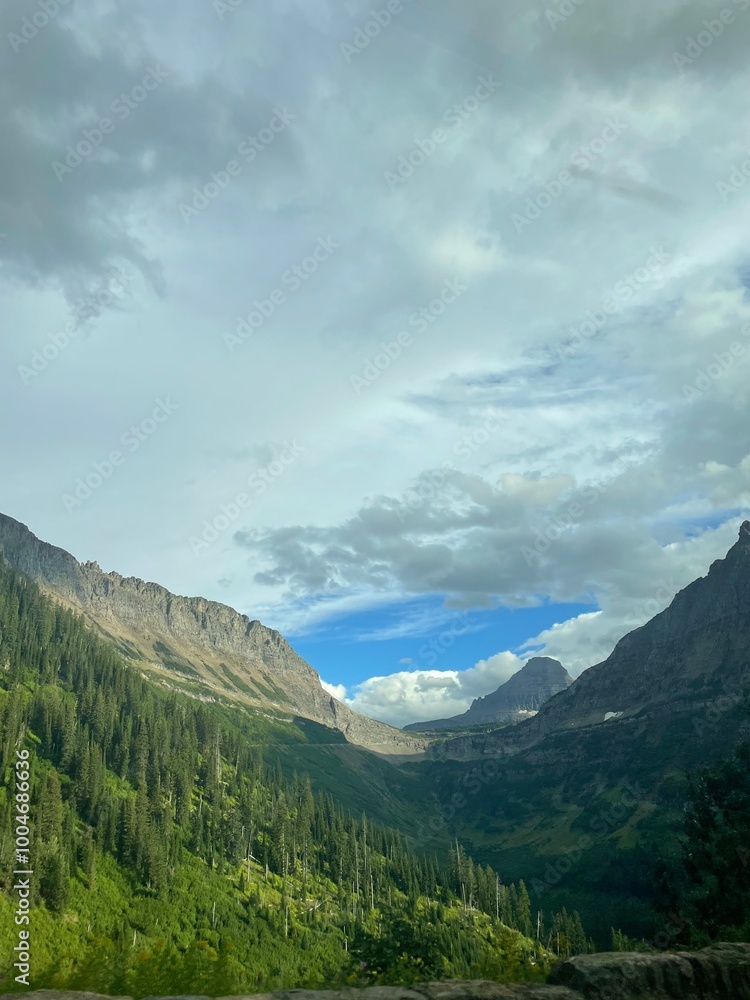 Naklejka premium Scenic views across Glacier National Park, featuring rugged mountains, alpine lakes, and pristine wilderness.