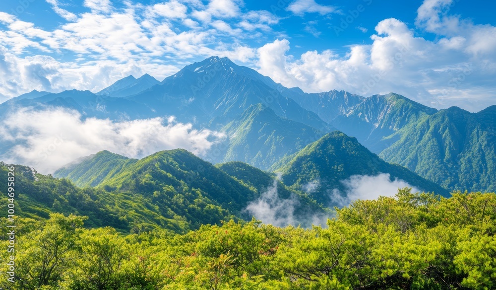 Obraz premium Lush green mountains stretch beneath a bright blue sky, with white clouds hovering over distant peaks in the morning sun