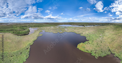 Big lake with green shores in bright sun light and city on horizon, aerial landscape. Recreation concept. Aerial view photo