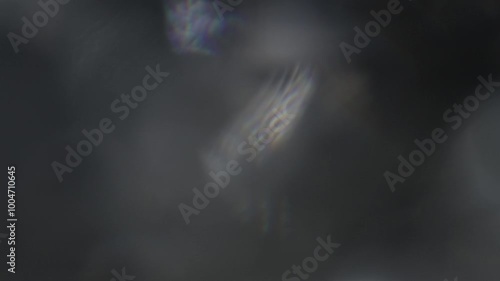 Light hitting a crystal glass creates different flashes of light on the camera lens, flowing across the screen as it shines photo