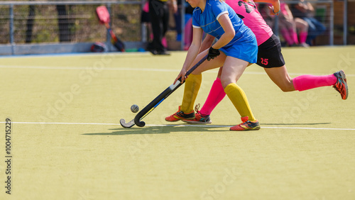 Photography Two athletes compete fiercely during a field hockey game on a bright and sunny d