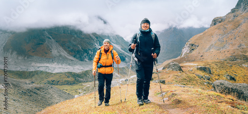 Fotografie Caucasian and Asian men with backpacks together following Makalu Barun Park trekking route near Khare
