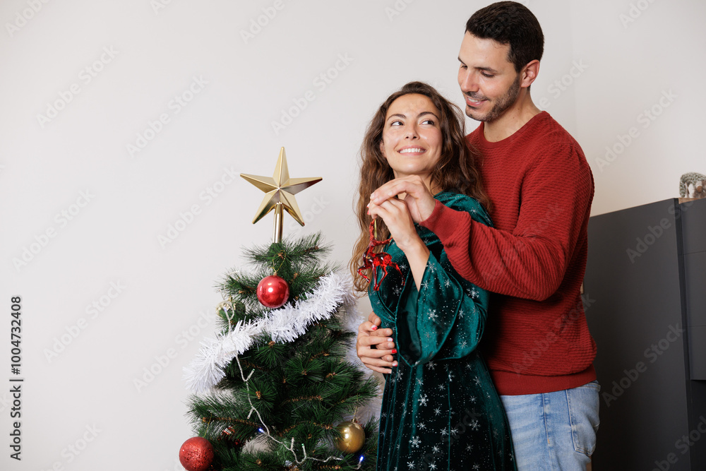 Young newlywed couple holding Christmas decorations in their hands to decorate their new home. Moments and experiences together that they will never forget. Young newlywed couple holding Christmas decorations in their hands to decorate their new home. Moments and experiences together that they will never forget.