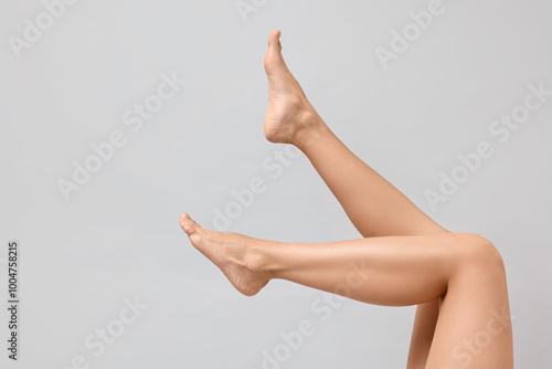 Woman with smooth legs on grey background, closeup. Space for text photo