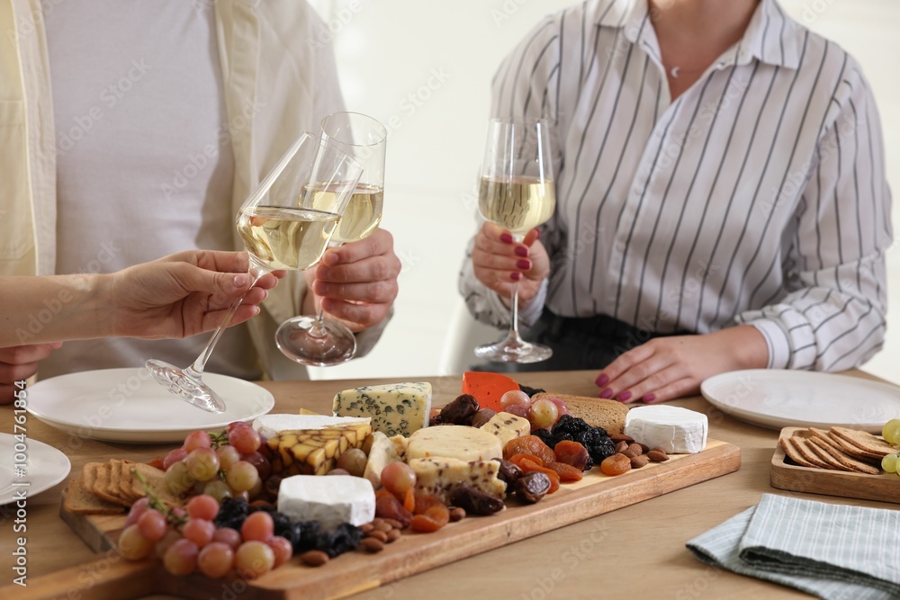 People clinking glasses of wine at served table, closeup People clinking glasses of wine at served table, closeup