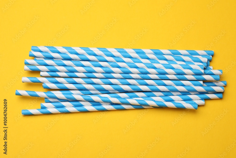 Paper drinking straws on yellow background, top view Paper drinking straws on yellow background, top view