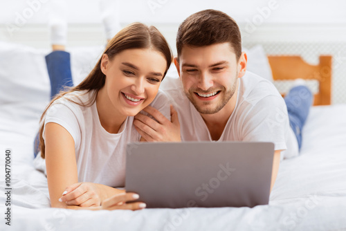 Boyfriend And Girlfriend Lying With Laptop Watching Film In Bedroom At Home. Weekend Together. Selective Focus