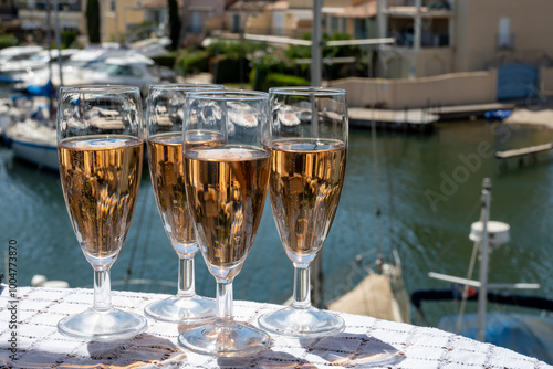 Summer party, French brut rose champagne sparkling wine in flute glasses in yacht harbour of Port Grimaud near Saint-Tropez, French Riviera vacation, Var, France photo