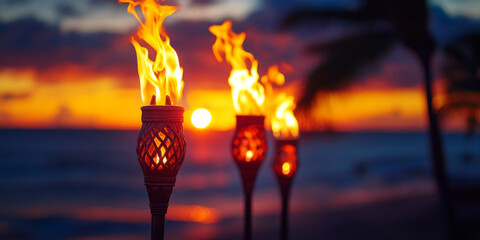 Hawaii luau party Maui fire tiki torches with open flames burning at sunset sky clouds at night