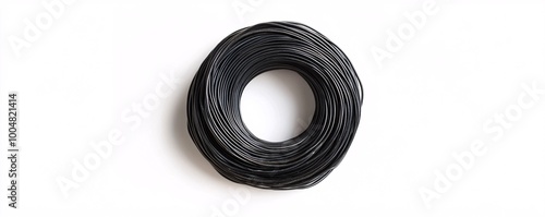 Black wire lying in coil shape on white background, forming perfect circle photo