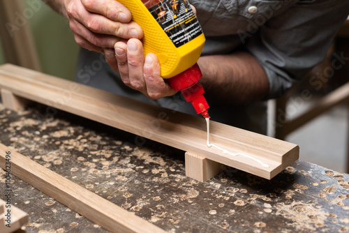 Joiner apply joiner's glue to the oak panel photo