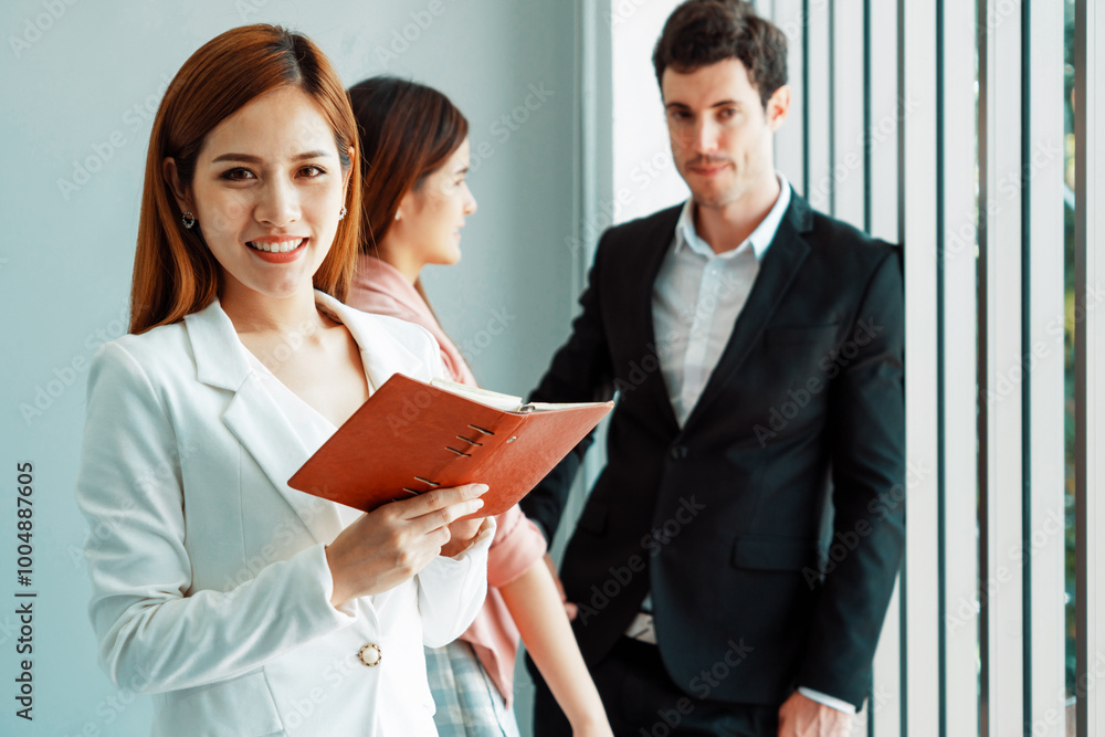 Happy young beautiful businesswoman reading book and working in office with colleagues and friend at workplace. Corporate business people group. uds Happy young beautiful businesswoman reading book and working in office with colleagues and friend at workplace. Corporate business people group. uds