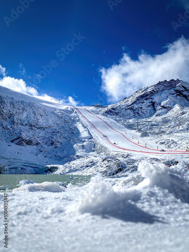 Soelden Rettenbachferner glacier, Austria with World Cup Giant Slalom ski race slope and lake infront against cloudy sky photo