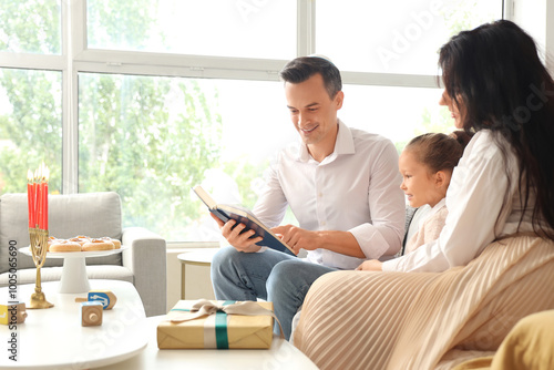 Happy family celebrating Hanukkah with Torah at home