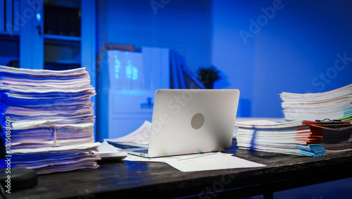 Tablou pe pânză stack of papers rests on a black wooden desk in a dimly lit office room